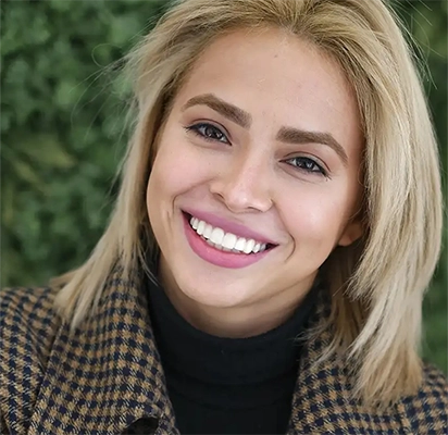 Mujer sonriente tras haber recibido un tratamiento de carillas de composite de Smysecret.