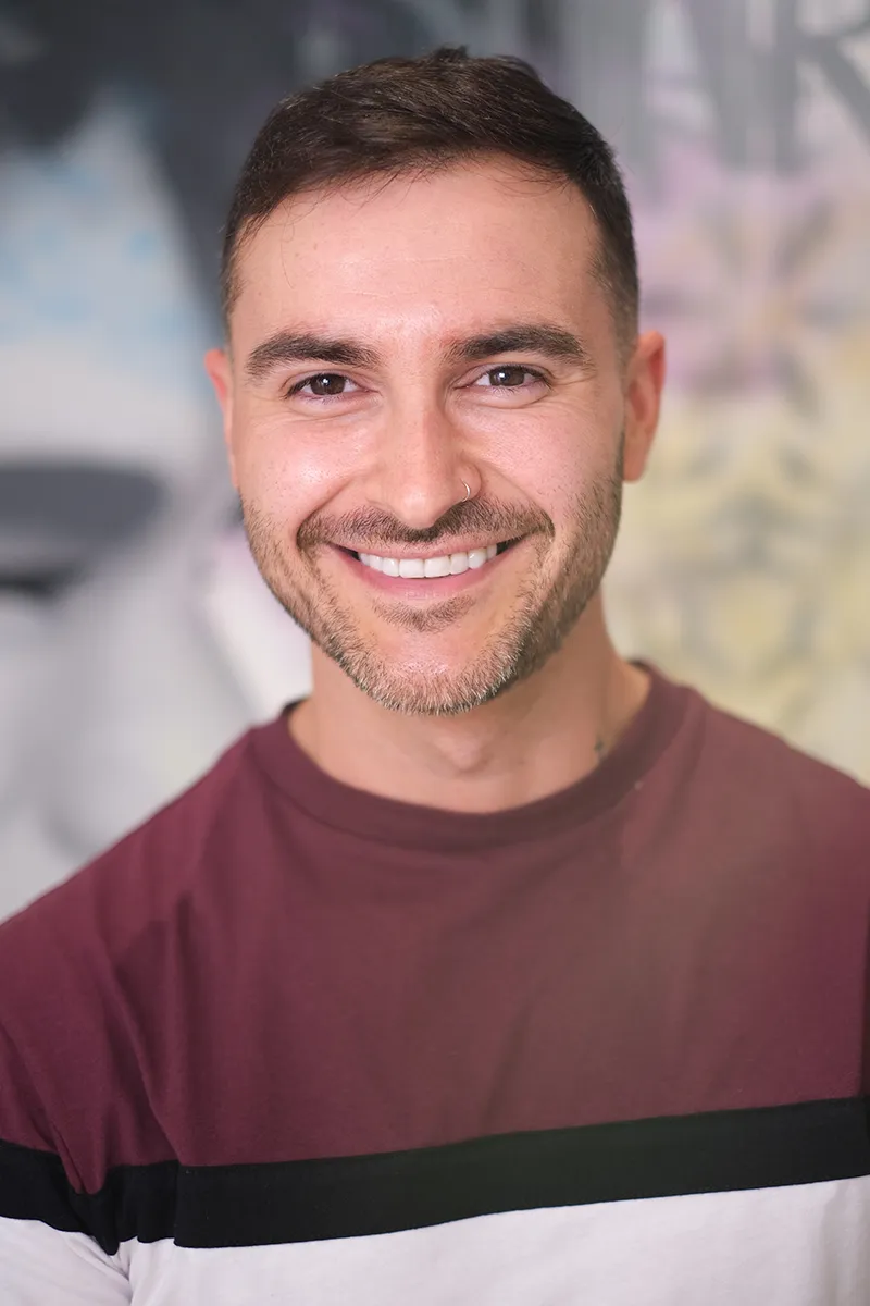 Chico sonriente después de recibir un tratamiento de carillas dentales de Smysecret.