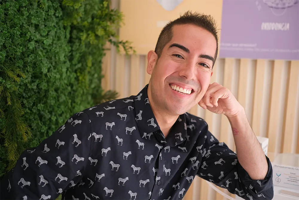 Hombre joven sonriente mostrando sus dientes tras un tratamiento exitoso de ortodoncia invisible en Smysecret.