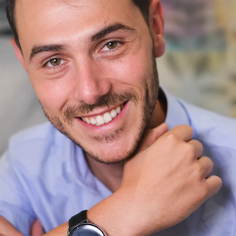 Hombre adulto sonriendo con dientes alineados después de usar ortodoncia invisible de Smysecret.